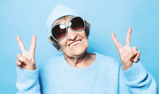 Une dame souriante fait le signe de la victoire. Grippe & Covid-19. Avec mes 2 vaccins, je crains dégun.