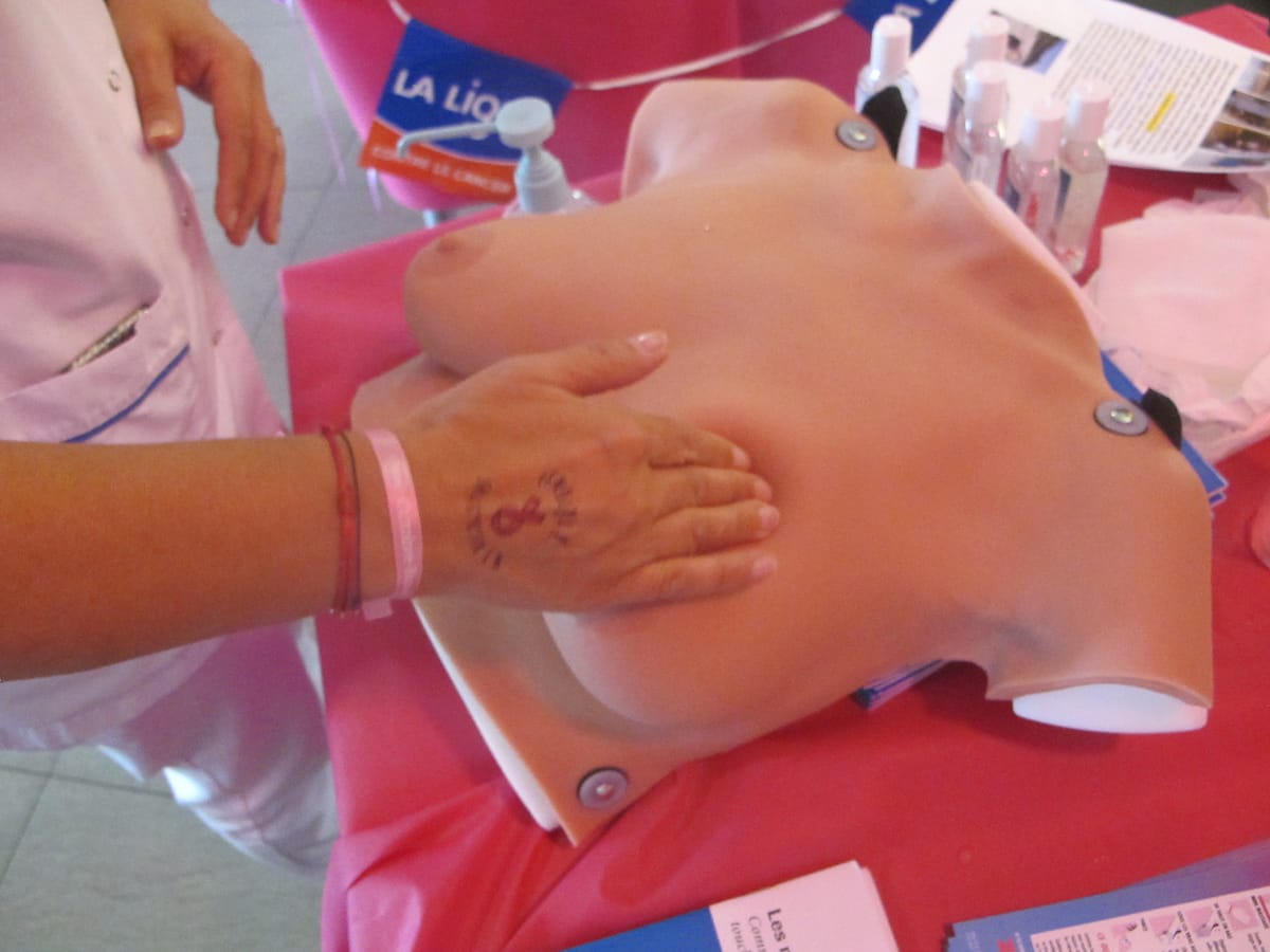 Une personne palpe un buste en silicone